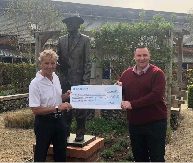 Darren handing over a cheque for £8206.50 to the Injured Jockeys Fund Chairman John Francome.