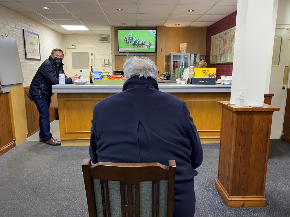 Charlie Dingwall, whose horse won Subway Surfs race, watching the replay in the winning connections room..