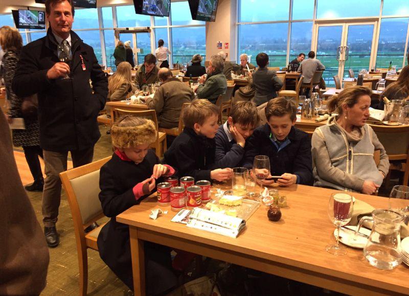 Nick Sutton watches the TV while Archie and his mates play on their phones at Cheltenham yesterday